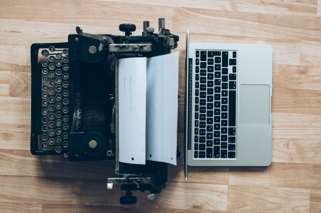 Eine alte Schreibmaschine neben einem modernen Laptop